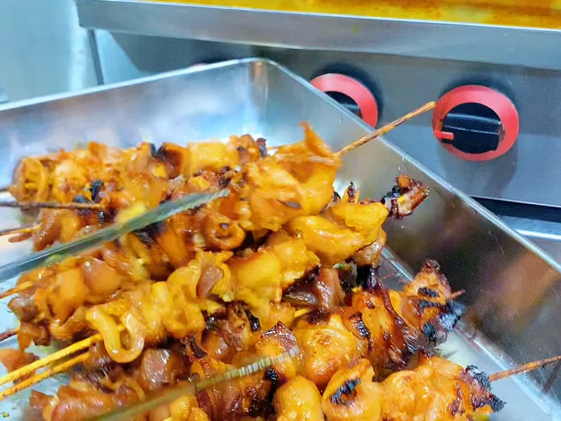 Khay thịt nướng xiên vàng óng vừa ra lò — khung hình từ video bài học khoá Bánh Mì Kinh Doanh