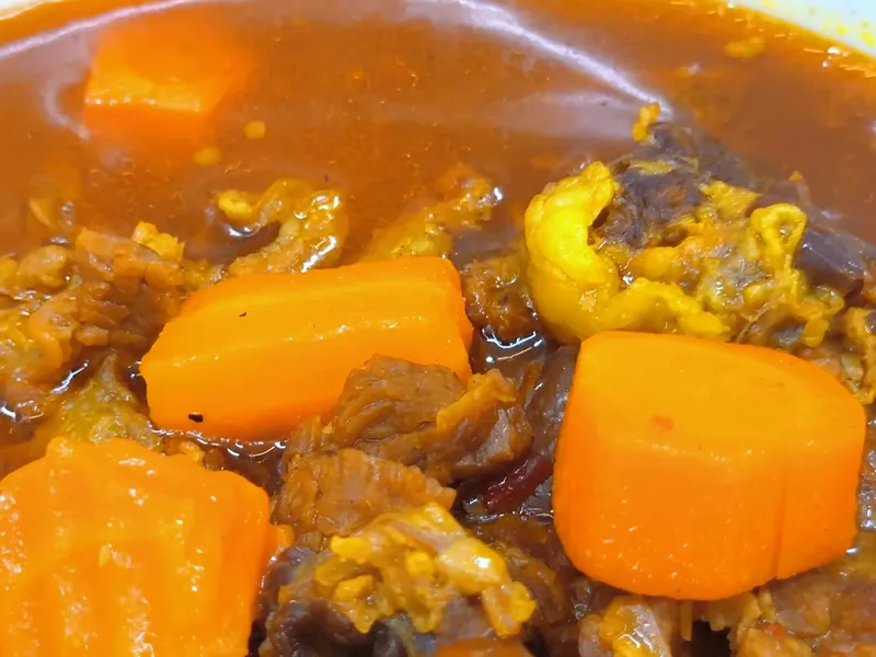 Cận cảnh thịt bò kho mềm thấm cùng cà rốt — khung hình từ video khoá Bò Kho