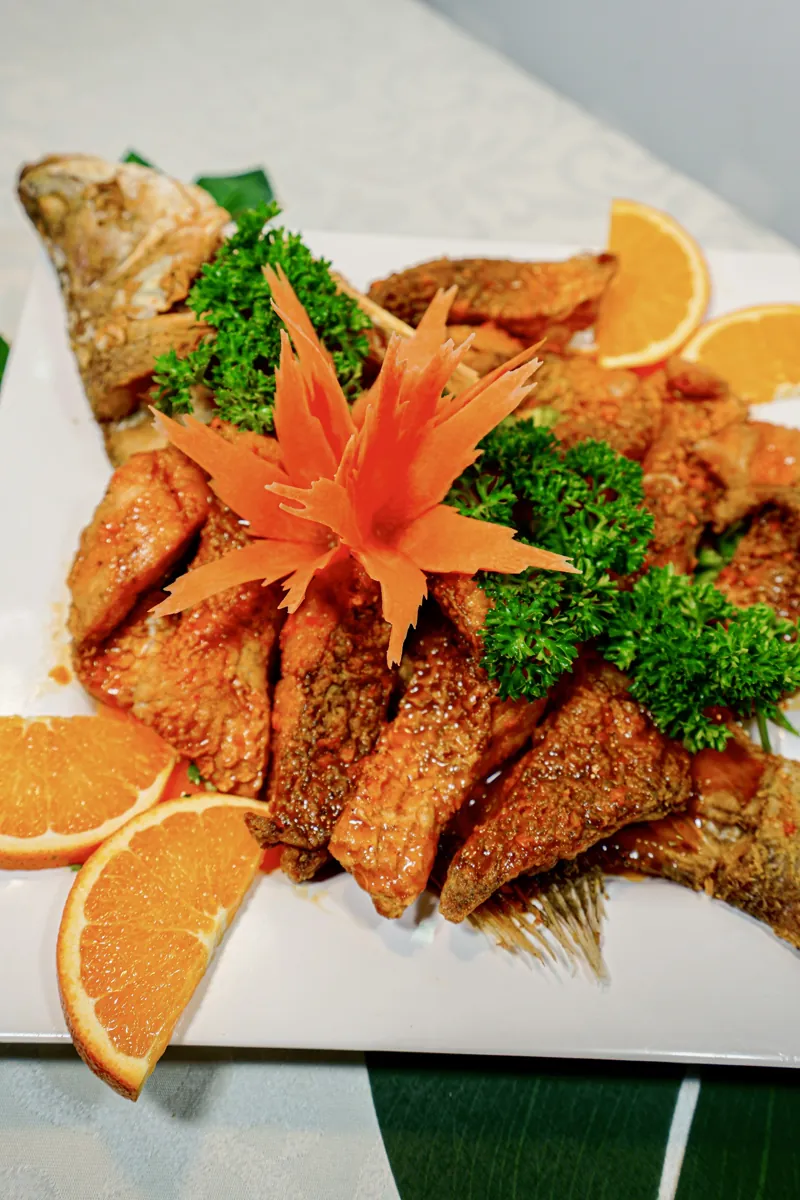 Cá chiên nguyên con cắt khúc bày dĩa cùng cam tươi