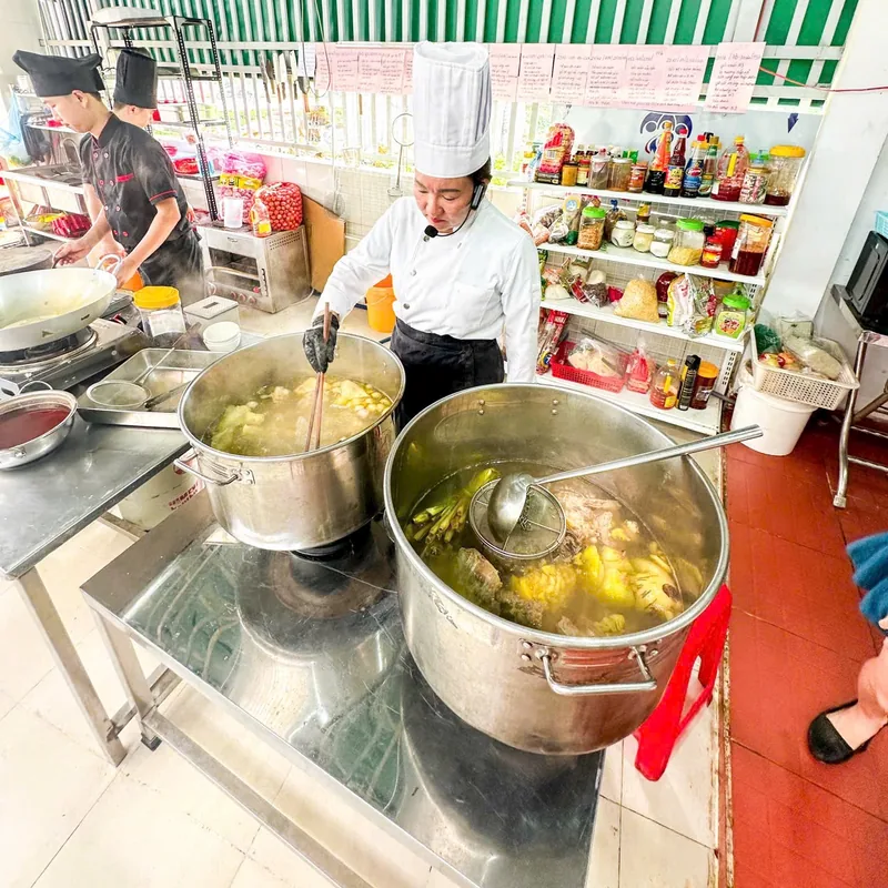 Cô Linh đang hướng dẫn nấu hai nồi nước dùng bún bò Huế cỡ lớn trong lớp học trực tiếp