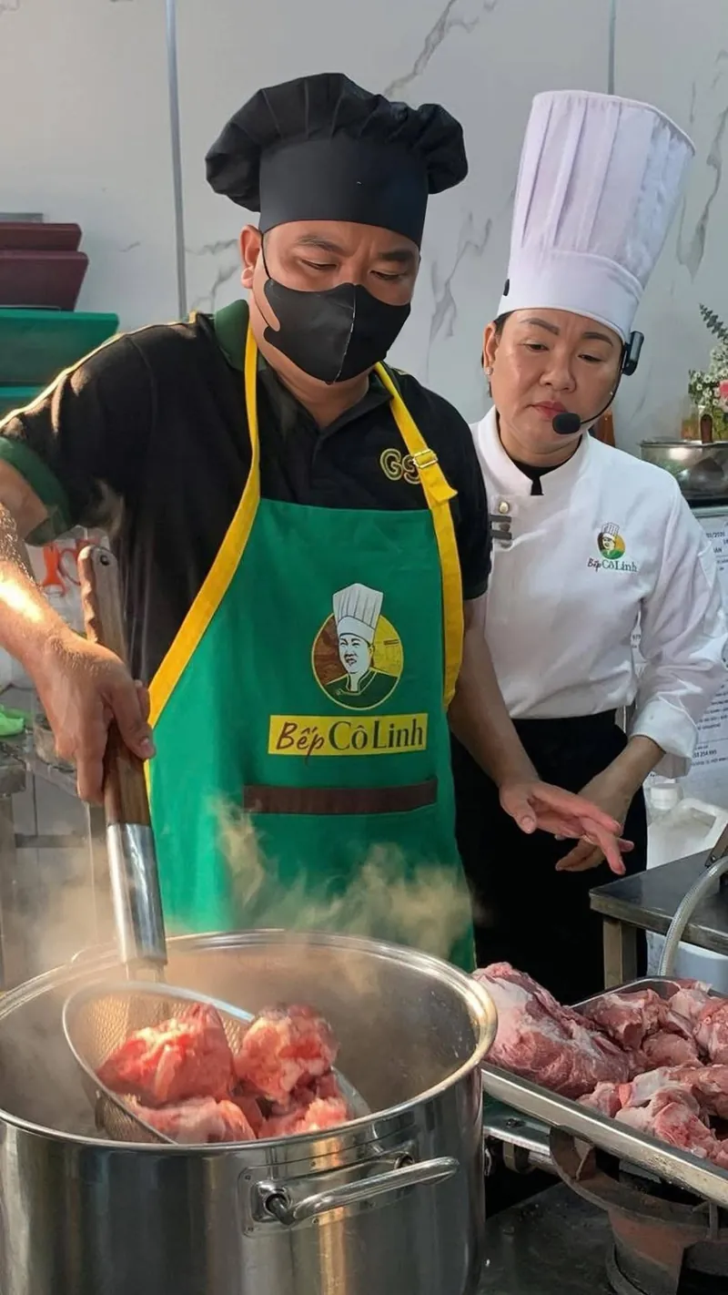 Cô Linh hướng dẫn học viên vớt nguyên liệu trong nồi nước nóng cỡ lớn tại lớp học bún bò Huế