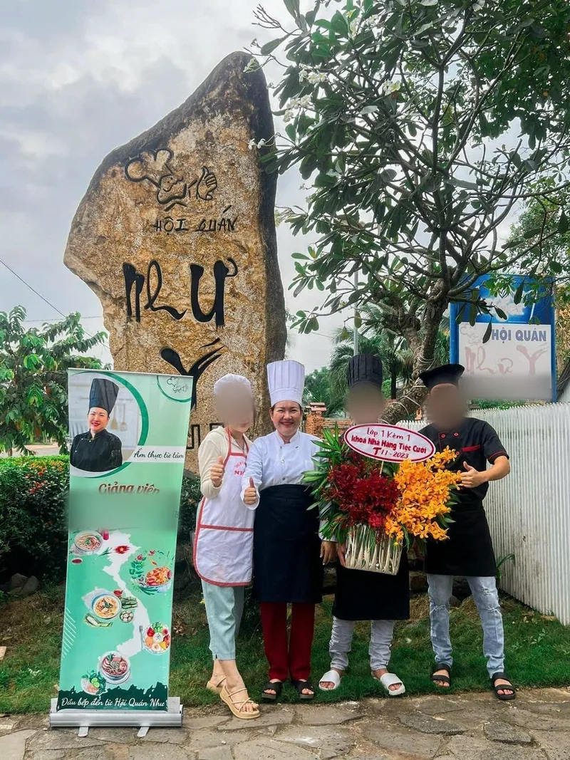 Cô Linh cùng học viên và đội trước Hội quán Như Ý trong ngày học lớp nấu tiệc 1 kèm 1 tháng 11/2023, cầm lẵng hoa chúc mừng