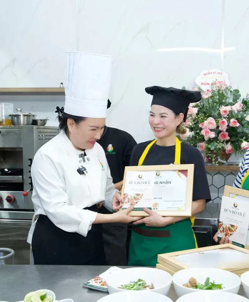 Cô Linh trao chứng nhận hoàn thành khoá Bún Bò Huế cho học viên tại lớp học trực tiếp
