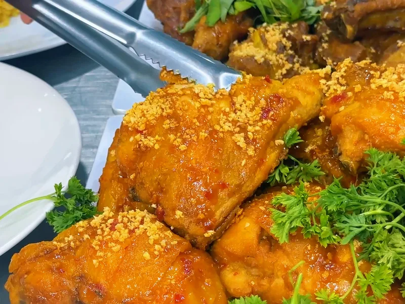 Gà xối mỡ phủ tỏi xào vàng và ngò tây — khung hình từ video khoá Cơm Gà Xối Mỡ