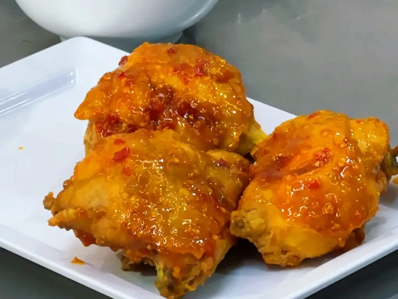 Miếng gà chiên quét sốt bơ tỏi bóng đỏ — khung hình từ video khoá Cơm Gà Xối Mỡ