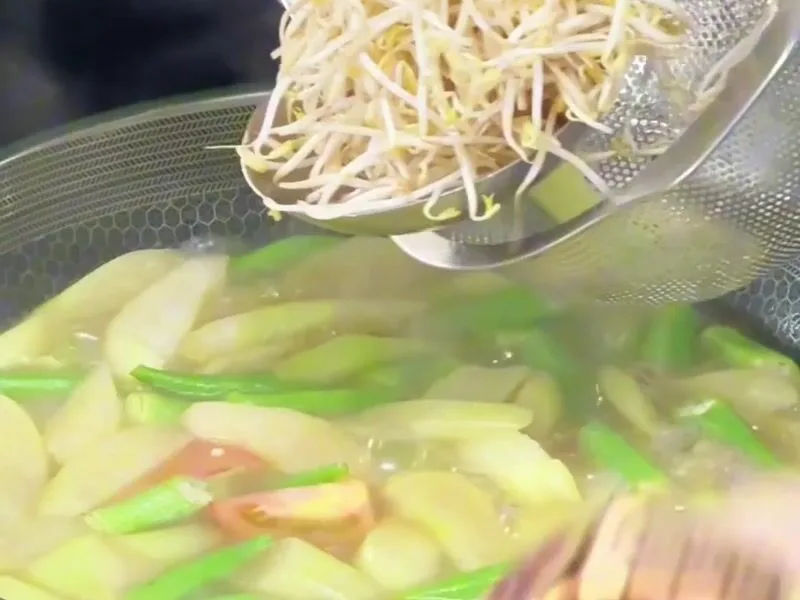 Thả giá vào nồi canh chua cá đang sôi — khung hình từ video bài học khoá Cơm Gia Đình