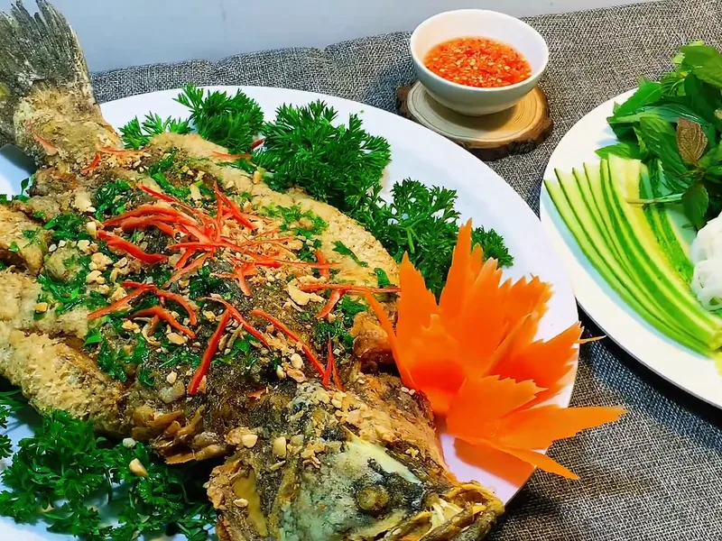 Cá chẽm chiên giòn rắc ớt, bày đĩa cùng rau sống — khung hình từ video khoá Combo Tiệc Online 1