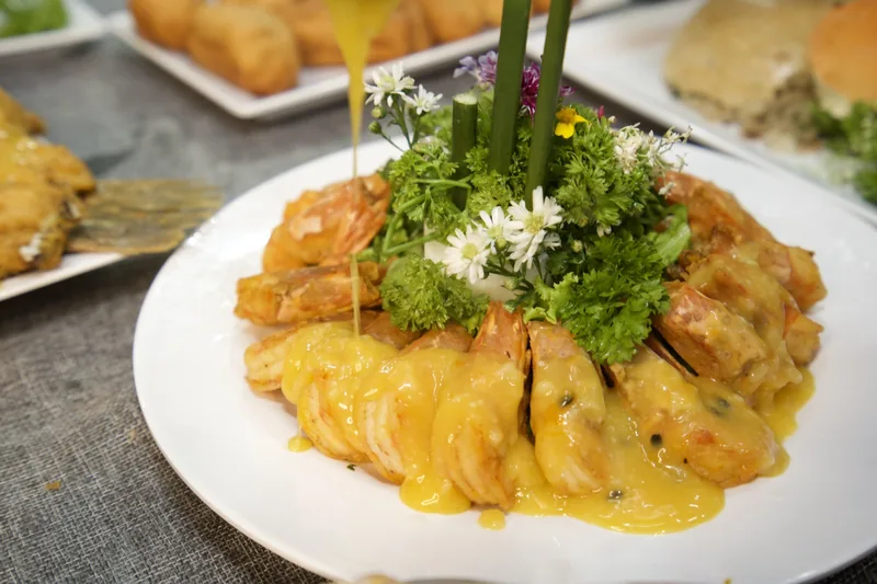 Đĩa tôm sốt trình bày hoa tươi và rau mùi tây trong lớp học nấu tiệc