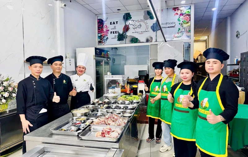 Đội ngũ Bếp Cô Linh và học viên khoá Bún Bò Huế chụp ảnh lưu niệm bên nguyên liệu đã sơ chế