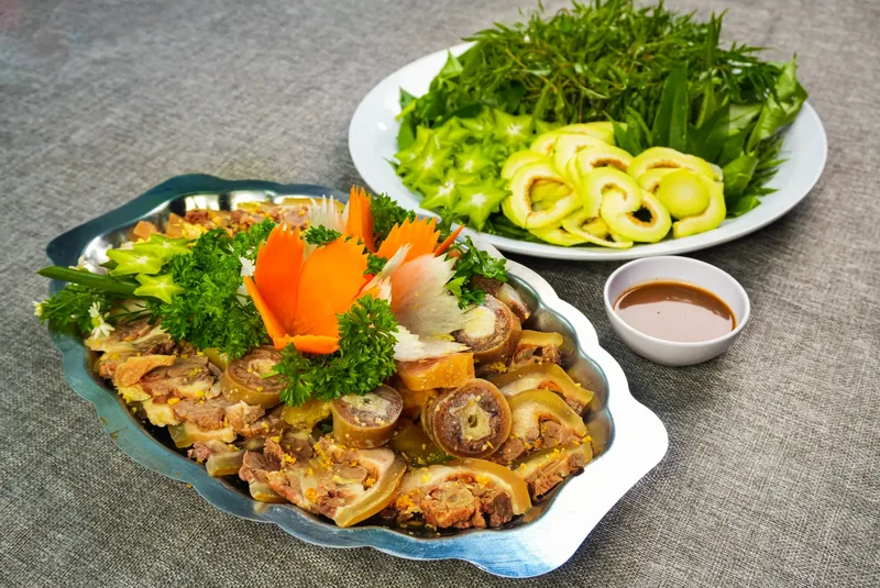 Đĩa đuôi bò hấp hành gừng chặt miếng nhỏ vừa ăn, trang trí hoa cà rốt, ăn kèm đĩa rau sống và chén nước chấm, do Bếp Cô Linh thực hiện