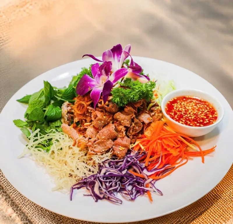 Gỏi bò ngũ sắc của Bếp Cô Linh: thịt bò thái mỏng, rau thơm, bắp cải tím và cà rốt bào sợi, kèm chén nước chấm