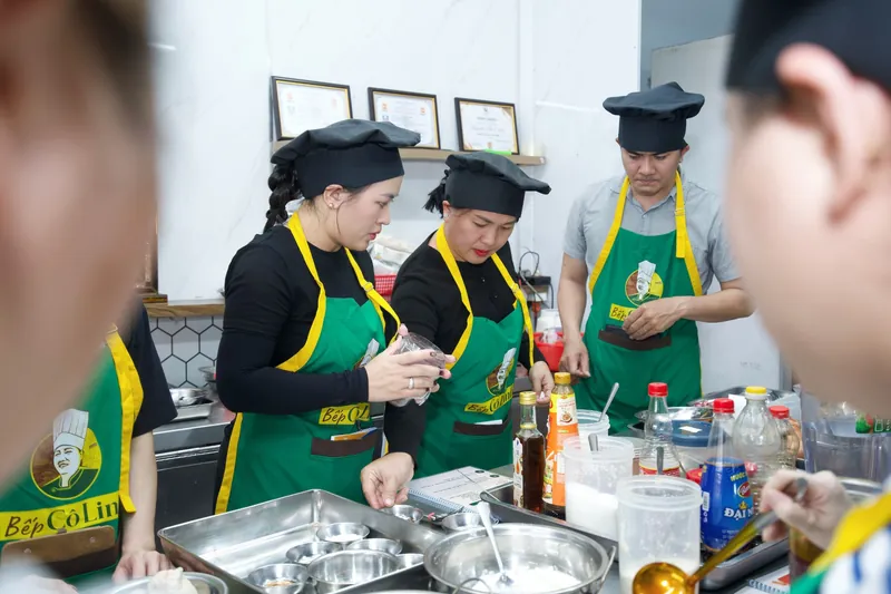 Học viên cân đo gia vị theo sổ công thức trong lớp học bún bò Huế trực tiếp tại Bếp Cô Linh