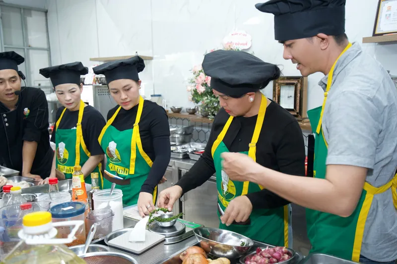 Học viên cân tiêu xanh bằng cân điện tử trong lớp học bún bò Huế trực tiếp