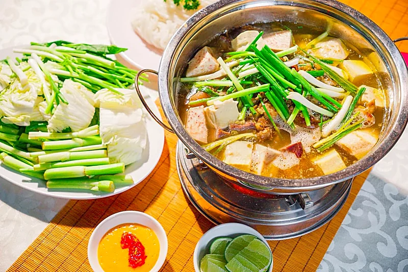 Nồi lẩu bò ăn kèm rau và sốt chấm chao, món tặng kèm trong khoá Phở Bò