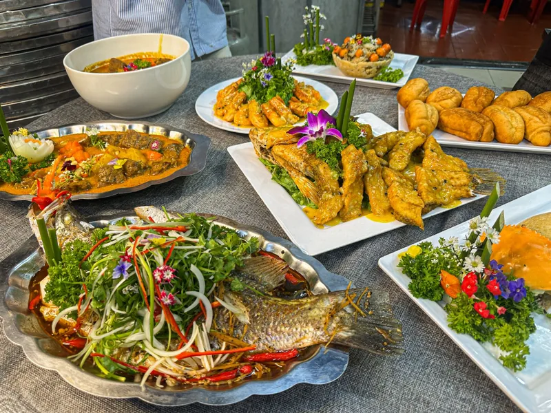Mâm tiệc nhiều món sau buổi học nấu tiệc: cá hấp, cá chiên sốt vàng, tôm sốt, bò sốt, bánh mì chiên và món trình bày hoa tươi