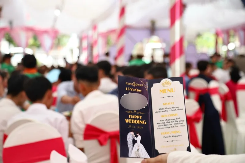 Thực đơn một tiệc cưới 7 món tại Đồng Nai, cầm trên tay giữa các bàn tiệc (tên cô dâu chú rể đã làm mờ)