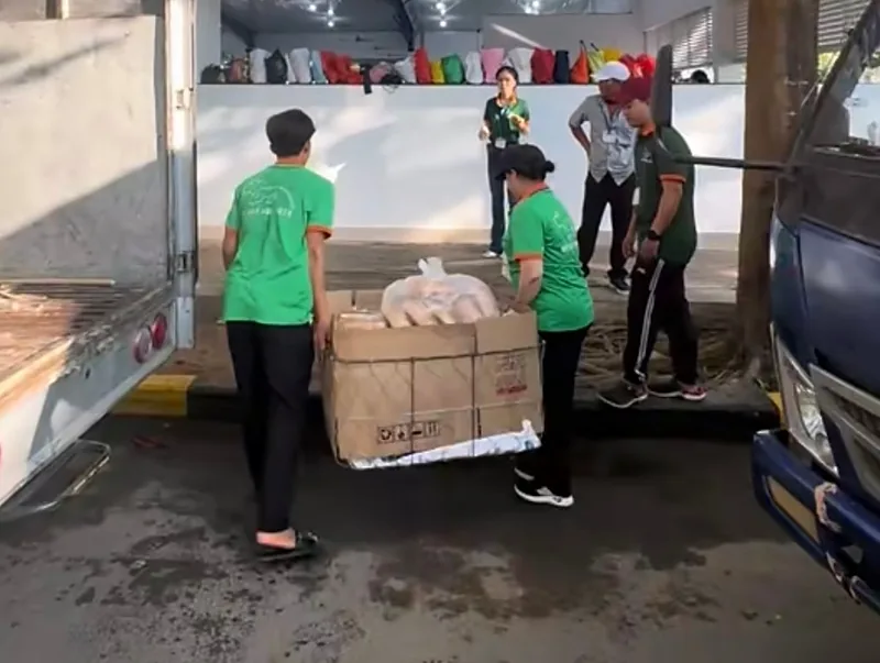 Đội bếp mặc áo xanh khiêng từng thùng hàng từ xe tải xuống khi đến nơi tiệc