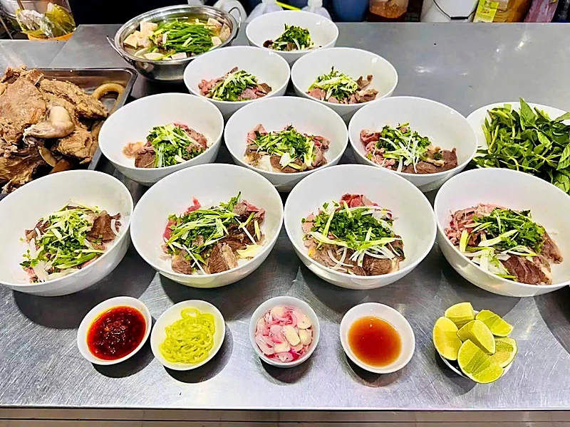 Các tô phở bò bày sẵn cùng ớt sa tế, ớt ngâm, hành ngâm và chanh